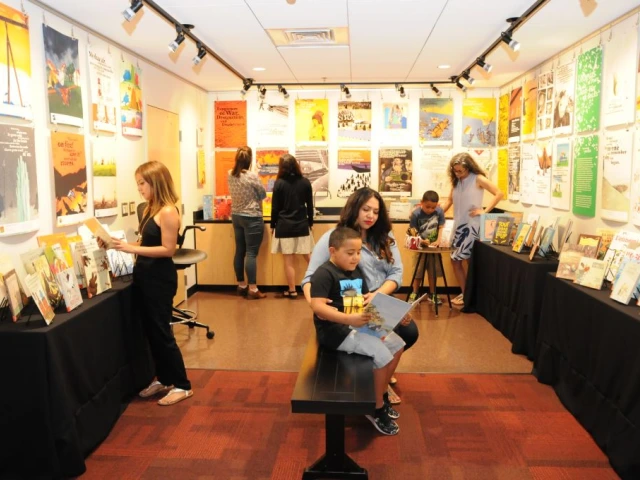 People in a gallery looking at books and posters