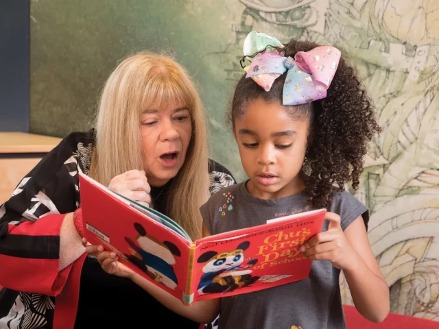 Worlds of Words Director Kathy Short reads a book with Khloey Steptoe.