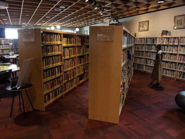 Student Worker, Aika Adamson maintains the Worlds of Words library during an open house exhibit.