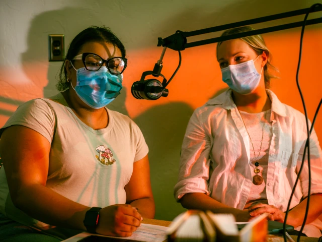 Woman listens to teen who talks into a microphone