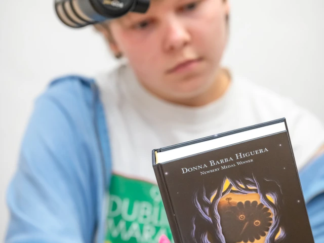 microphone in foreground and boy considers a book in background