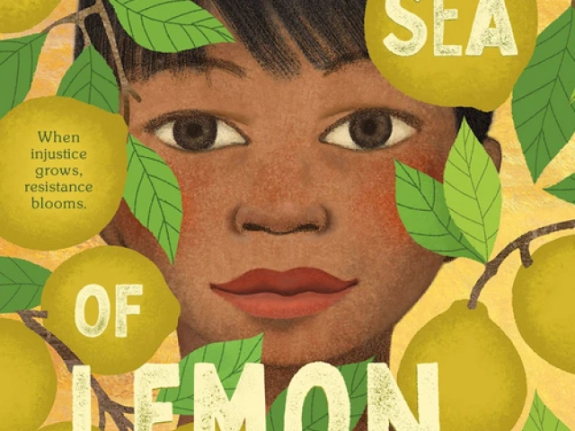 A young boy peers out to the viewer from between branches and leaves of a lemon tree.