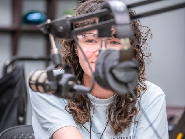teen peeks through microphone equipment