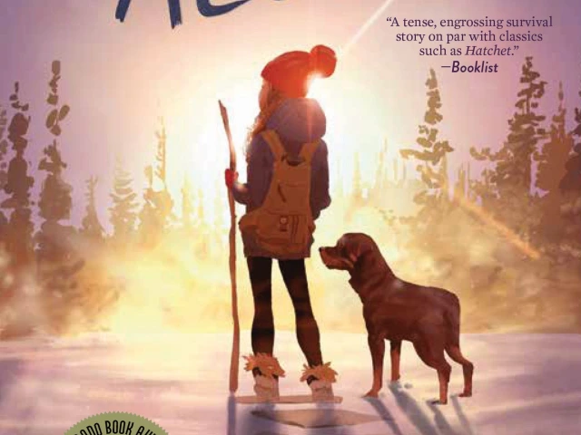 A young girl in winter gear stands outside in the snow with a dog. 