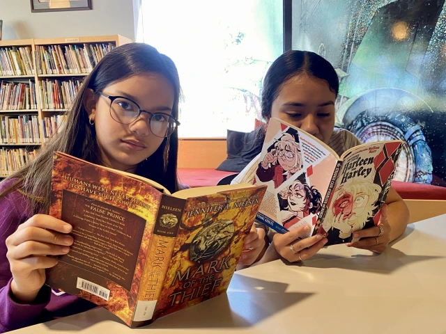 Two young people reading different books