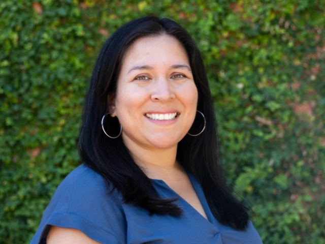Portrait of a smiling woman with long, straight black hair