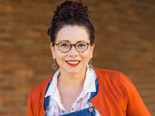 Picture of Donna Barba Higuera, a woman with curly brown hair up in a bun and glasses. 