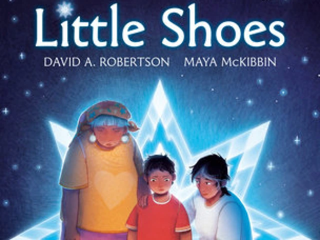 A young Indigenous boy looks down at a memories of candles, toys, flowers, and shoes with his mother and grandmother.