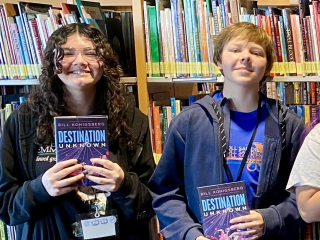 Teens hold copies of the same book