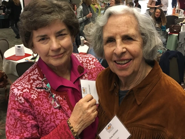 Marilyn Carpenter on left with Tony Johnston on the right smile for the camera at a conference.