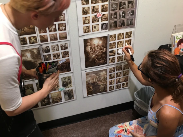 Teens post word bubbles on copies of interior illustrations from the book, The Arrival