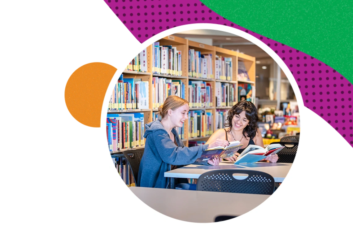 Two people reading books in a library