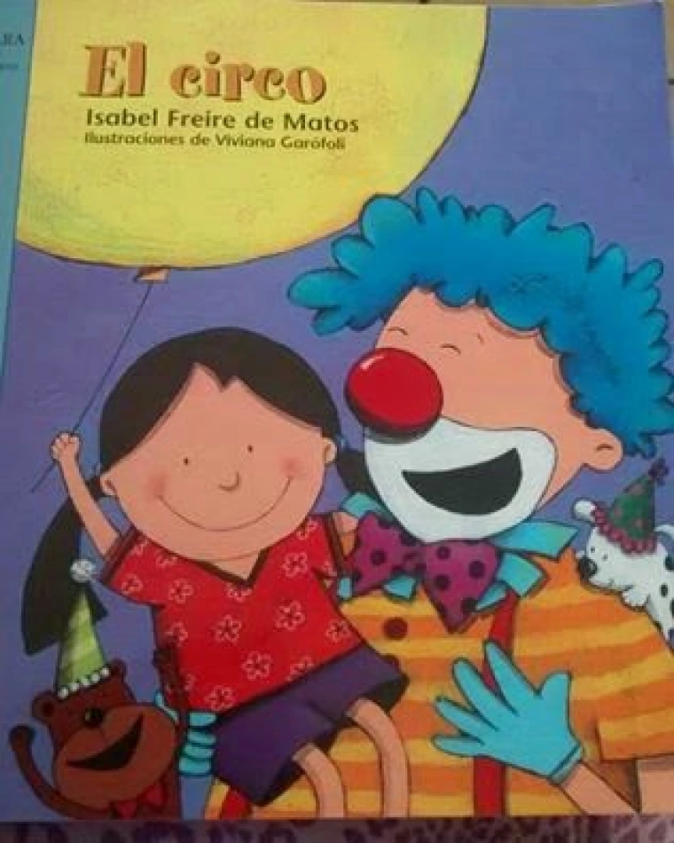 A smiling clown holds a young girl who has a yellow balloon.