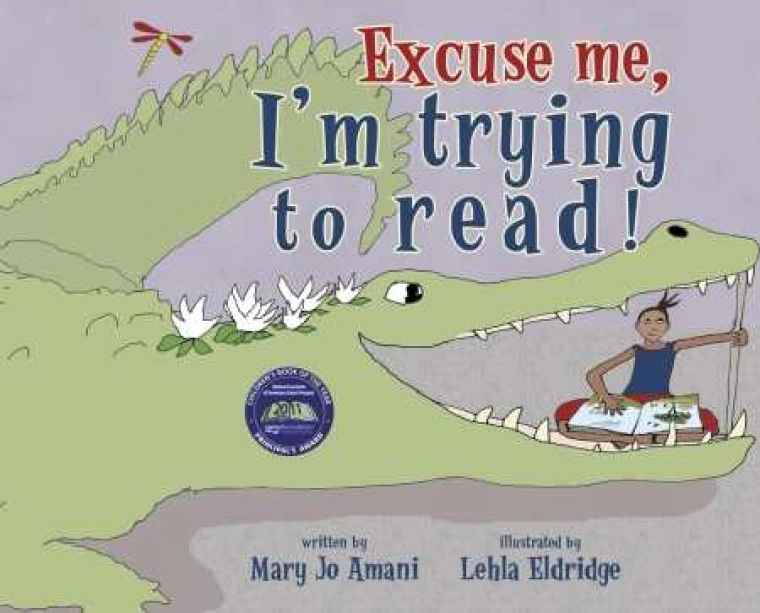 A kid is reading a book inside an alligator but is propping the alligator open with a stick