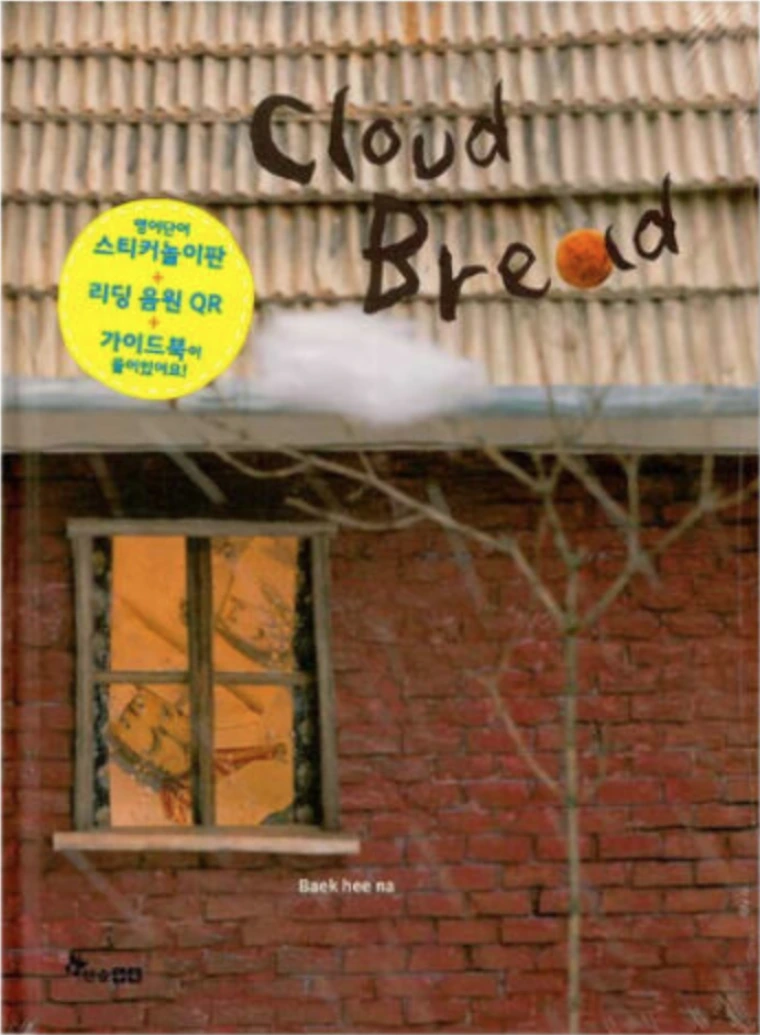 A cloud stuck on the branches of a tree in front of a brick house