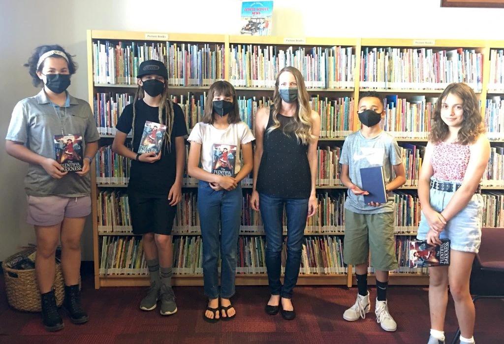 Group of young adults holding books 