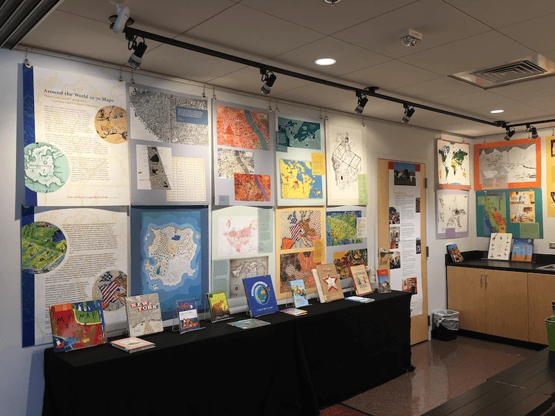 Photo of unoccupied studio with about half the posters and books on display.