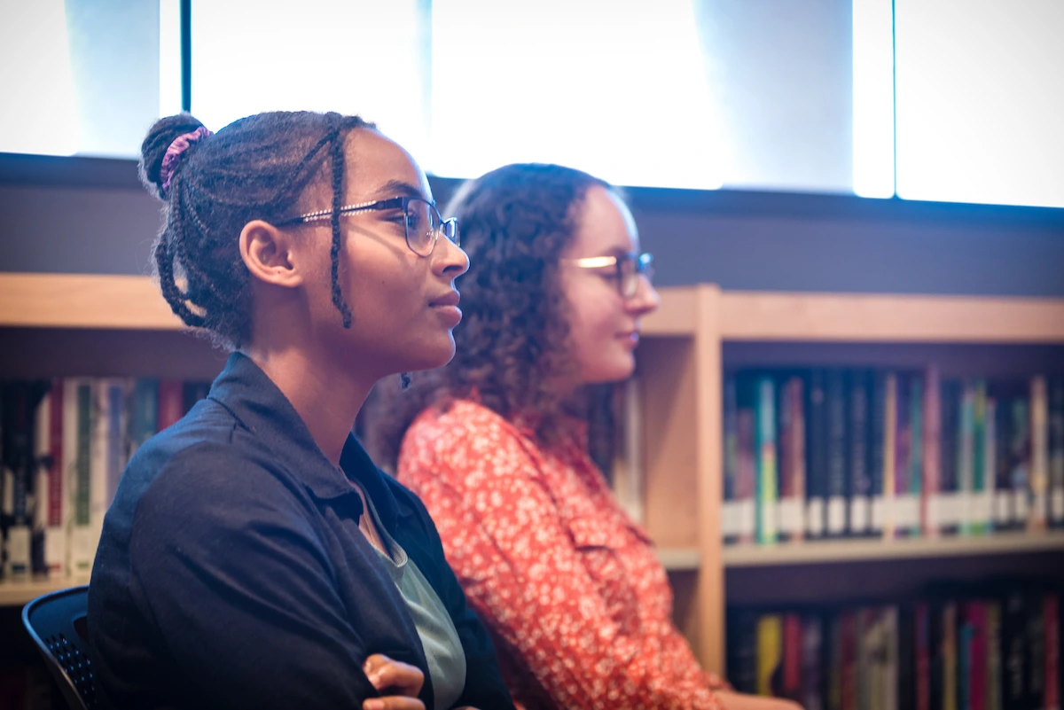 Profile of two ambassadors actively listening at an author event.