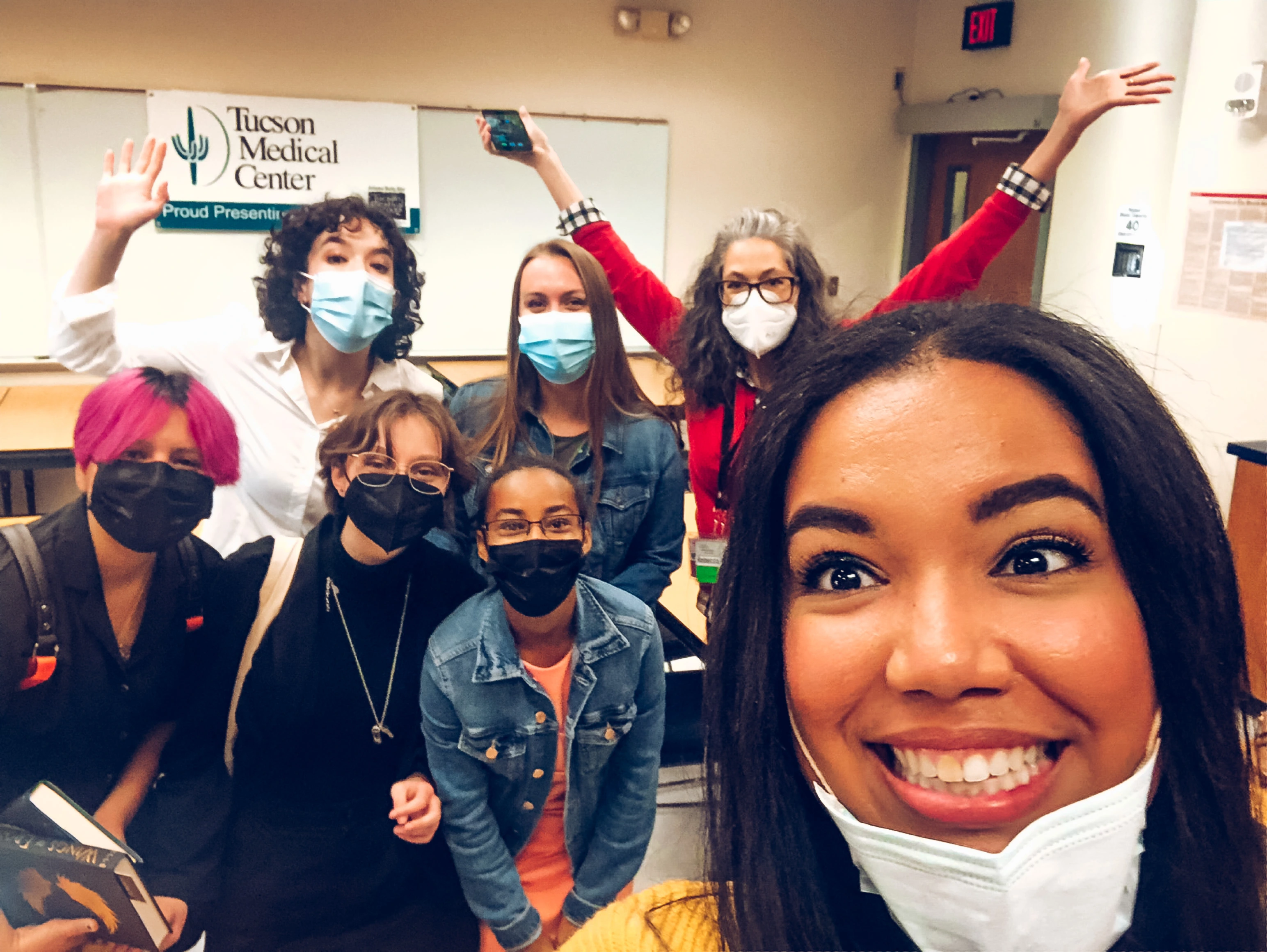 J. Elle in foreground taking a selfie with members of the reading ambassador program enthusiastically posing in the background