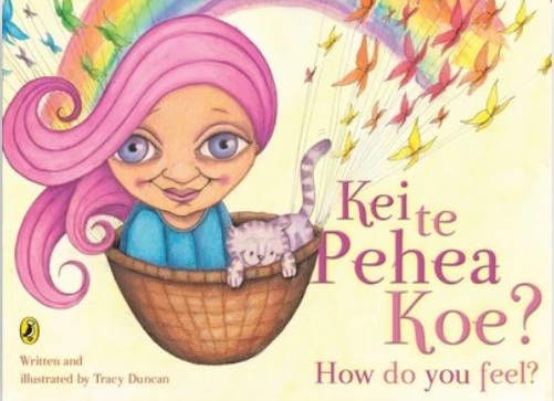 Cover of Kei Te Pehea Koe? with a woman with pink hair and a grey cat in a bastket in front of a rainbow