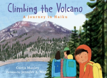 A young boy smiles at the viewer as he hikes with his parents to a mountain.