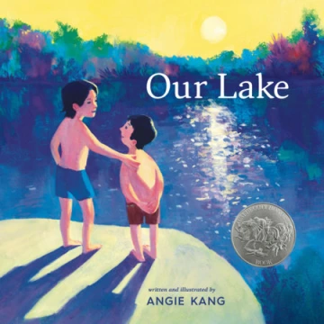 Two boys in swim trunks stand in front of a blue lake.