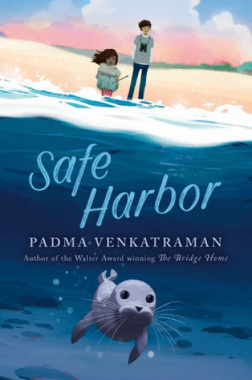 Two teens stand on the beach. Below the water is a seal pup.
