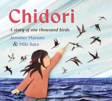 A young girl paints ink birds that fly over an ocean made of blue paper.