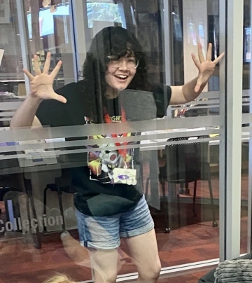 teen girl pretends to be trapped behind glass