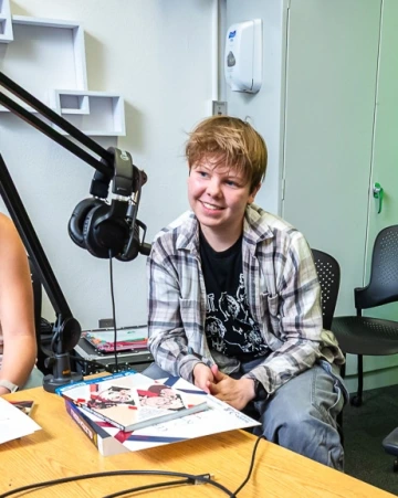 teen boy smiles into microphone