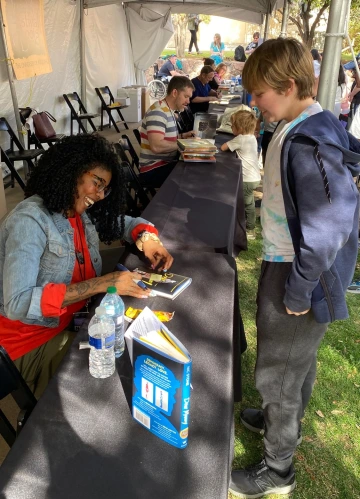 Teen boy gets a book signed by an author