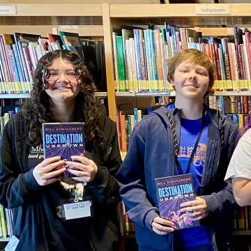 Teens hold copies of the same book
