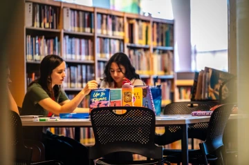 Middle schoolers study at a table in a library