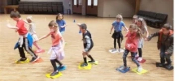 children moving around on a wooden floor with rags under their feet