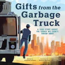A man in a uniform hands outside the door of a garbage truck looking out at a big city.