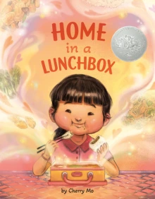 A young girl happily eats from her lunchbox.
