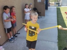child breaks through finish ribbon