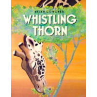 A giraffe leans down from above the cover to eat leaves off a bush.
