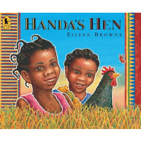 Two African children stand in a field of grass with a hen.