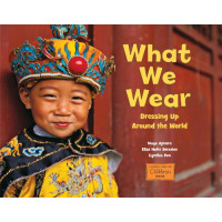 A young boy in yellow traditional Chinese clothes smiles at the camera.