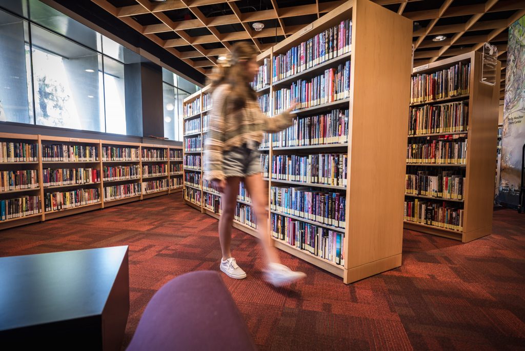 Teen browses bookshelves