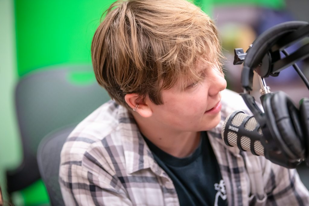 Teen speaks into professional podcasting microphone