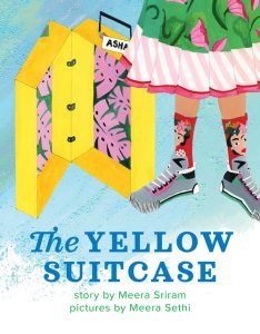 An open yellow suitcase next to the legs of a young girl