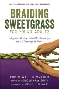Two pairs of brown hands braid a rope of the sweetgrass plant.