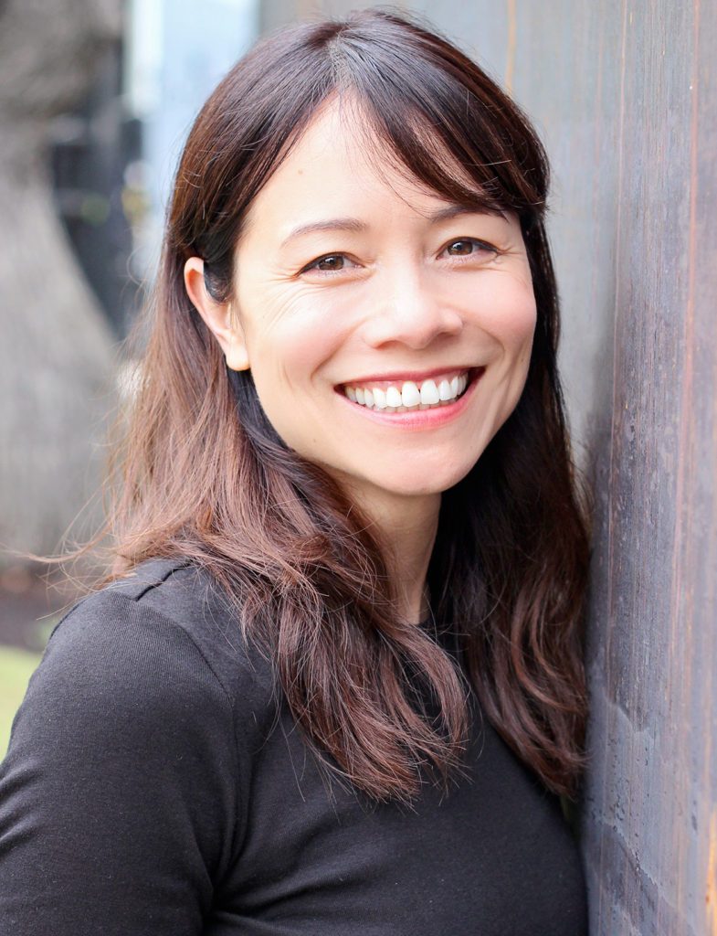 Head shot of Christina Soontornvat smiling in an outdoor environment.