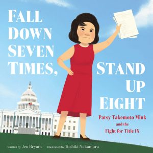 A Japanese American woman with short black hair in a red dress stands before the white house holding papers in her hands.