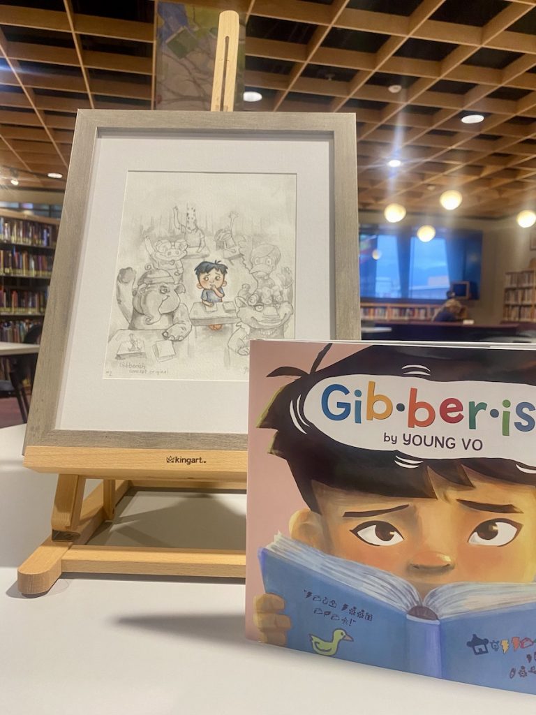 Concept art for Gibberish on a table easel displayed with a final copy of the book
