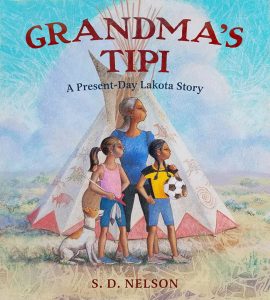 An older Lakota woman stands in front of a tipi with two girls and a dog