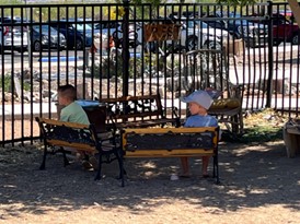 children sit at benches set in a circle