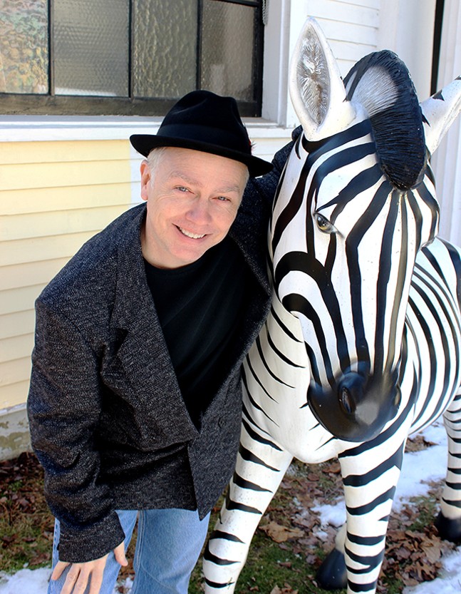 Jonha Winter posing next to a zebra statue.